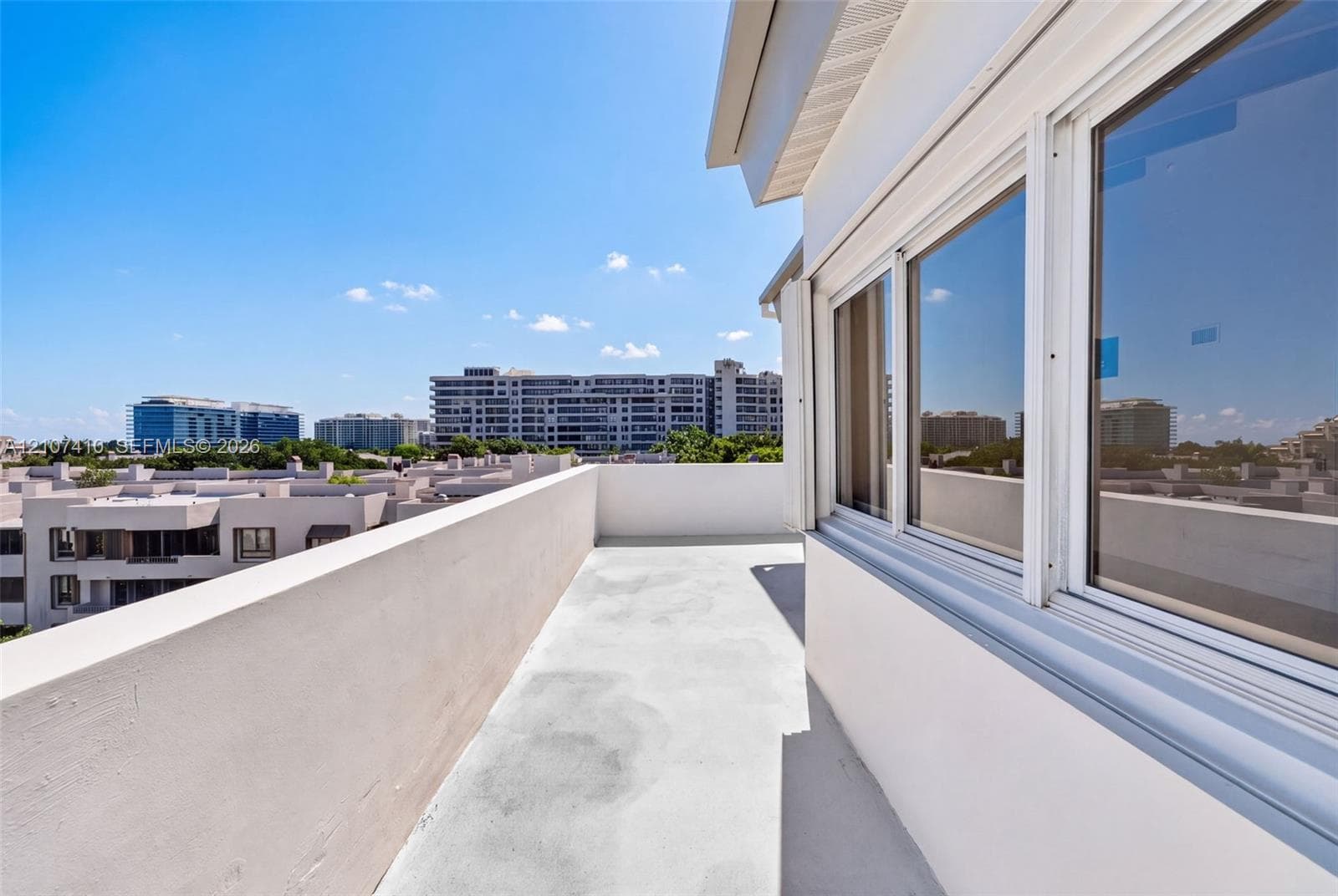 Rooftop terrace featuring solid masonry perimeter walls, concrete flooring, and multi-pane aluminum-framed windows