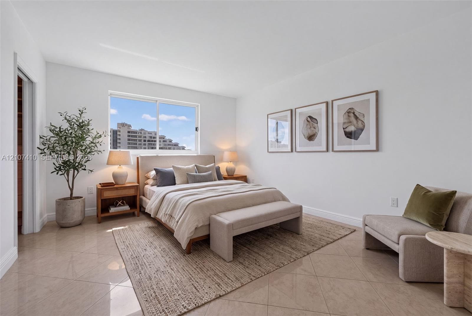 Neutral-toned tile flooring, oversized window, and crisp white wall finish