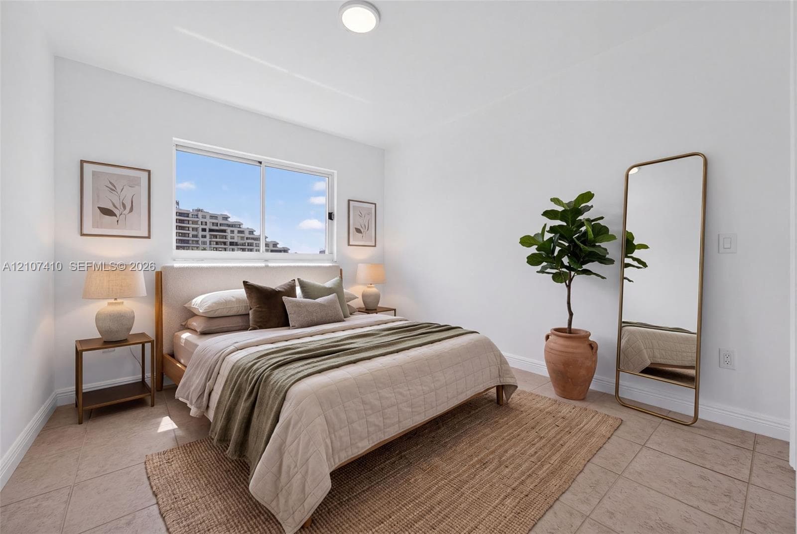 Bright bedroom featuring neutral tile flooring, a large sliding window, and a flush-mount ceiling light