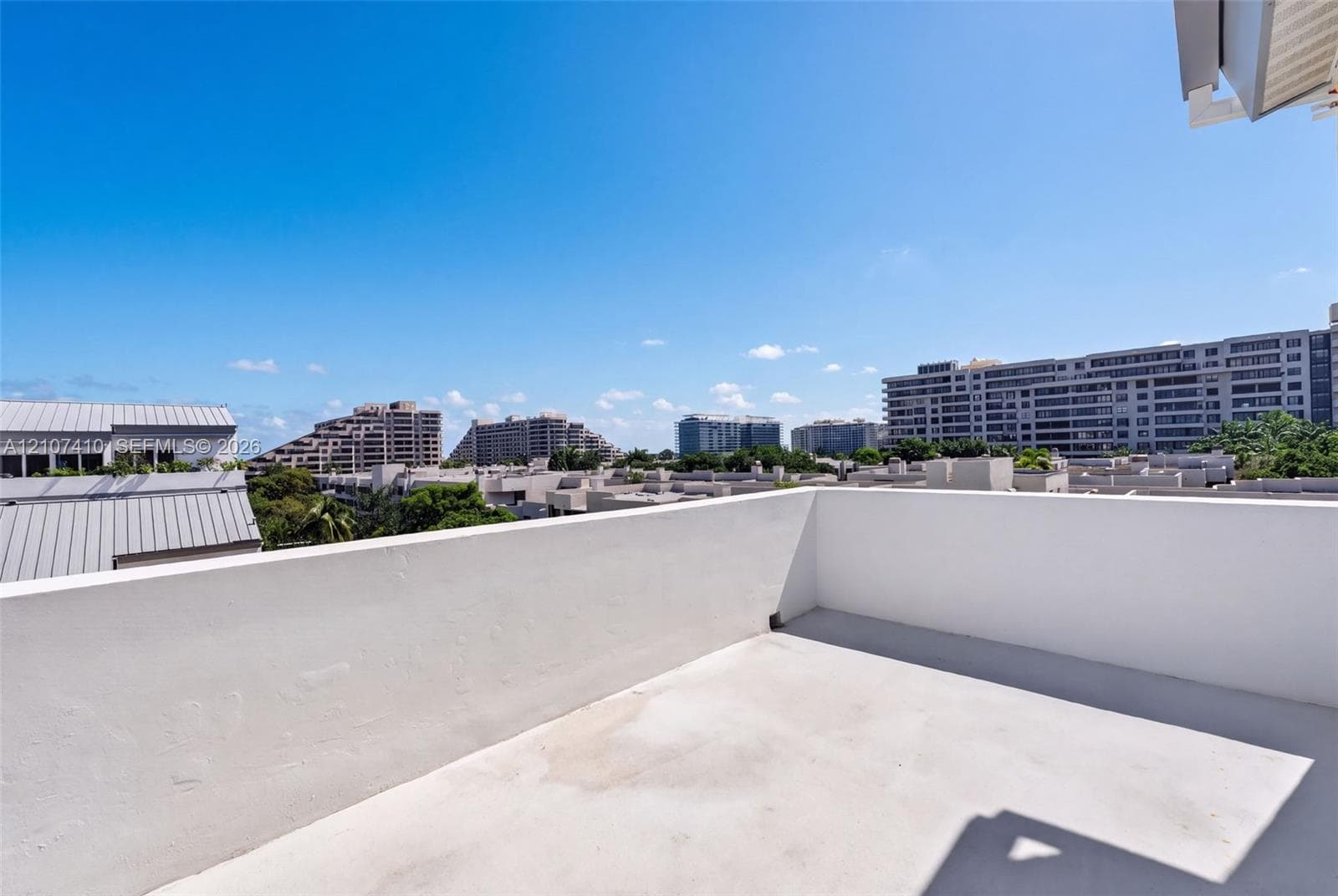 Open-air balcony with solid perimeter wall and concrete flooring
