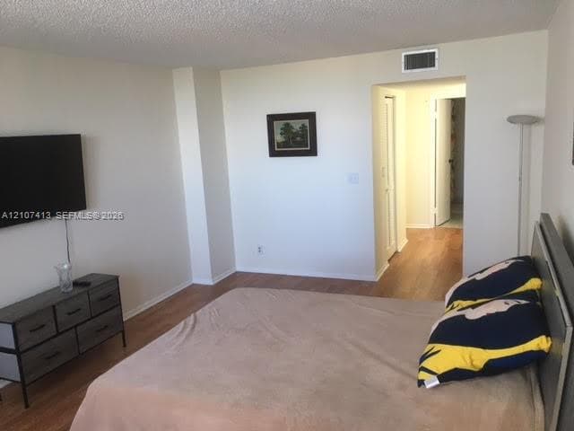 Room featuring wood-finish flooring and neutral wall paint