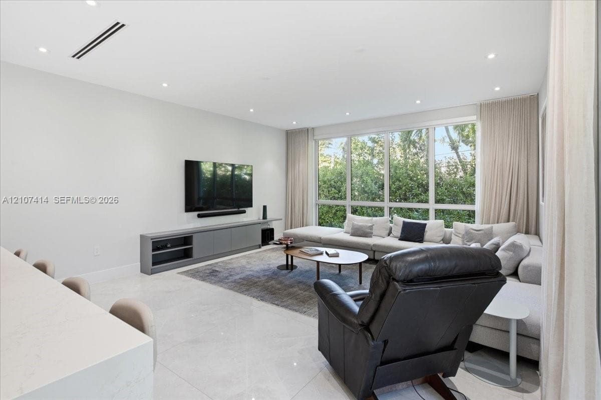 Living area featuring recessed ceiling lighting, linear air diffusers, large-format tile flooring, built-in cabinetry, and floor-to-ceiling windows