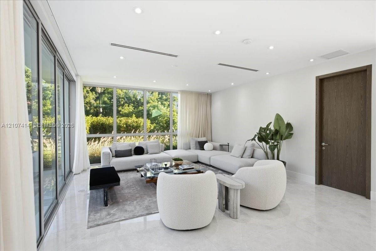 Floor-to-ceiling windows, polished stone flooring, recessed ceiling lighting, and a dark-finish interior door