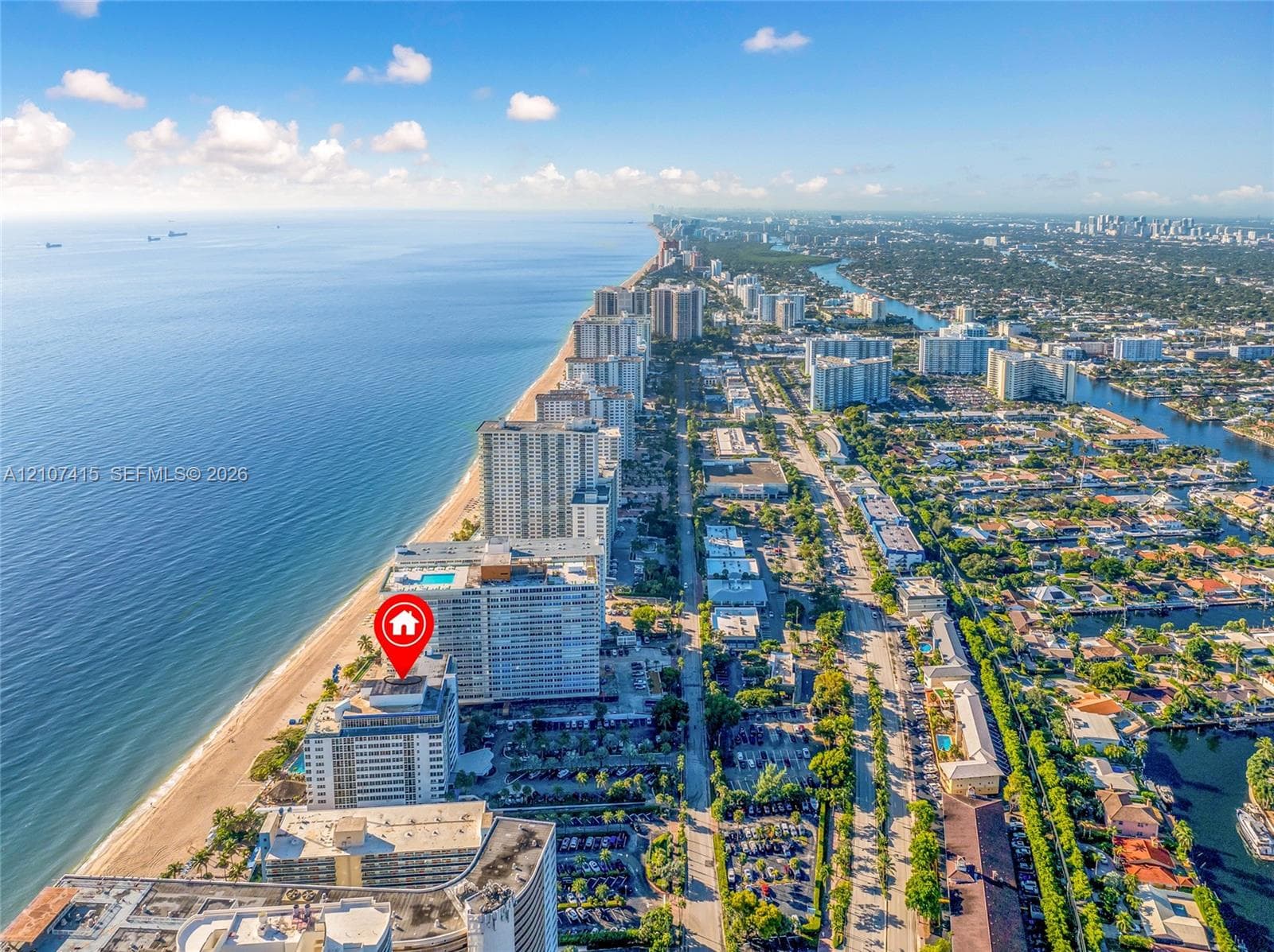 Aerial perspective of coastal high-rise development featuring direct oceanfront positioning and immediate proximity to the shoreline