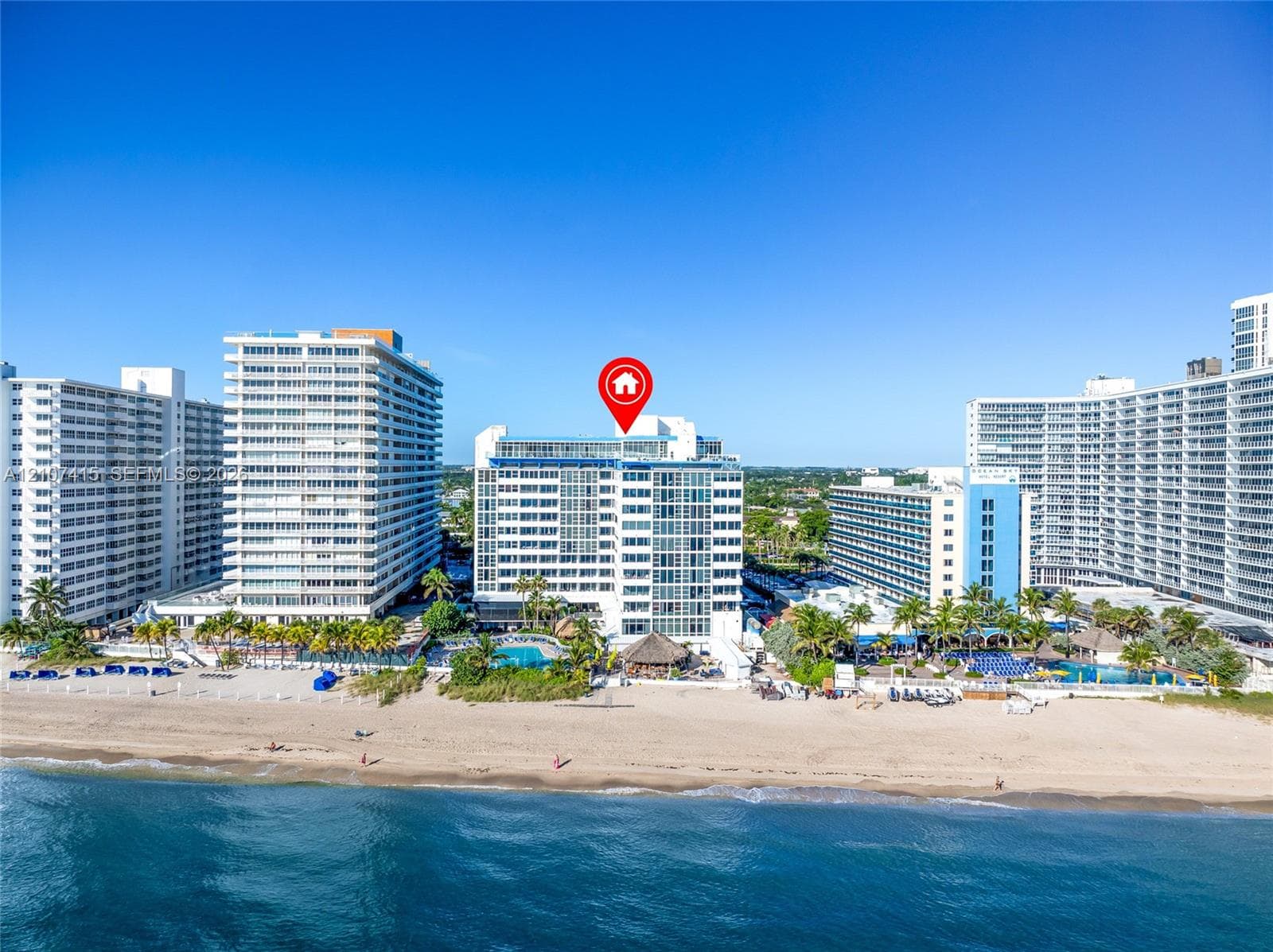 High-rise beachfront condominium building featuring direct ocean access, coastal exterior architecture, and multiple levels of glass-paneled balconies
