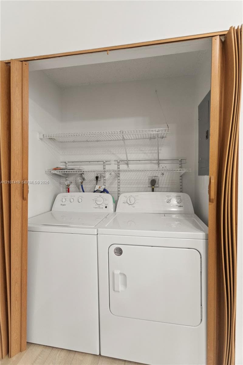 Laundry alcove featuring folding wood-finish doors and two levels of wall-mounted wire shelving