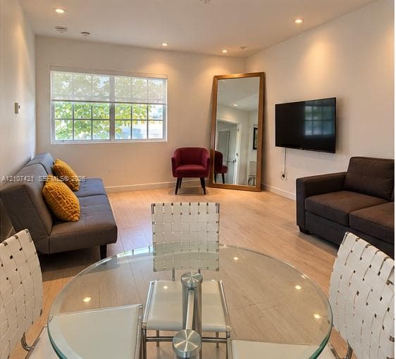 Light-filled interior featuring wood-finish flooring, recessed lighting, and a multi-pane window