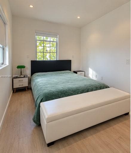 Neutral-toned interior featuring wood-finish flooring, recessed lighting, and multi-pane windows with integrated roller shades