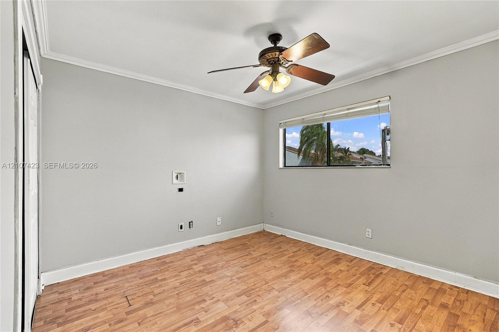 Wood-finish flooring, neutral wall tones, multi-light ceiling fan, and horizontal window blinds