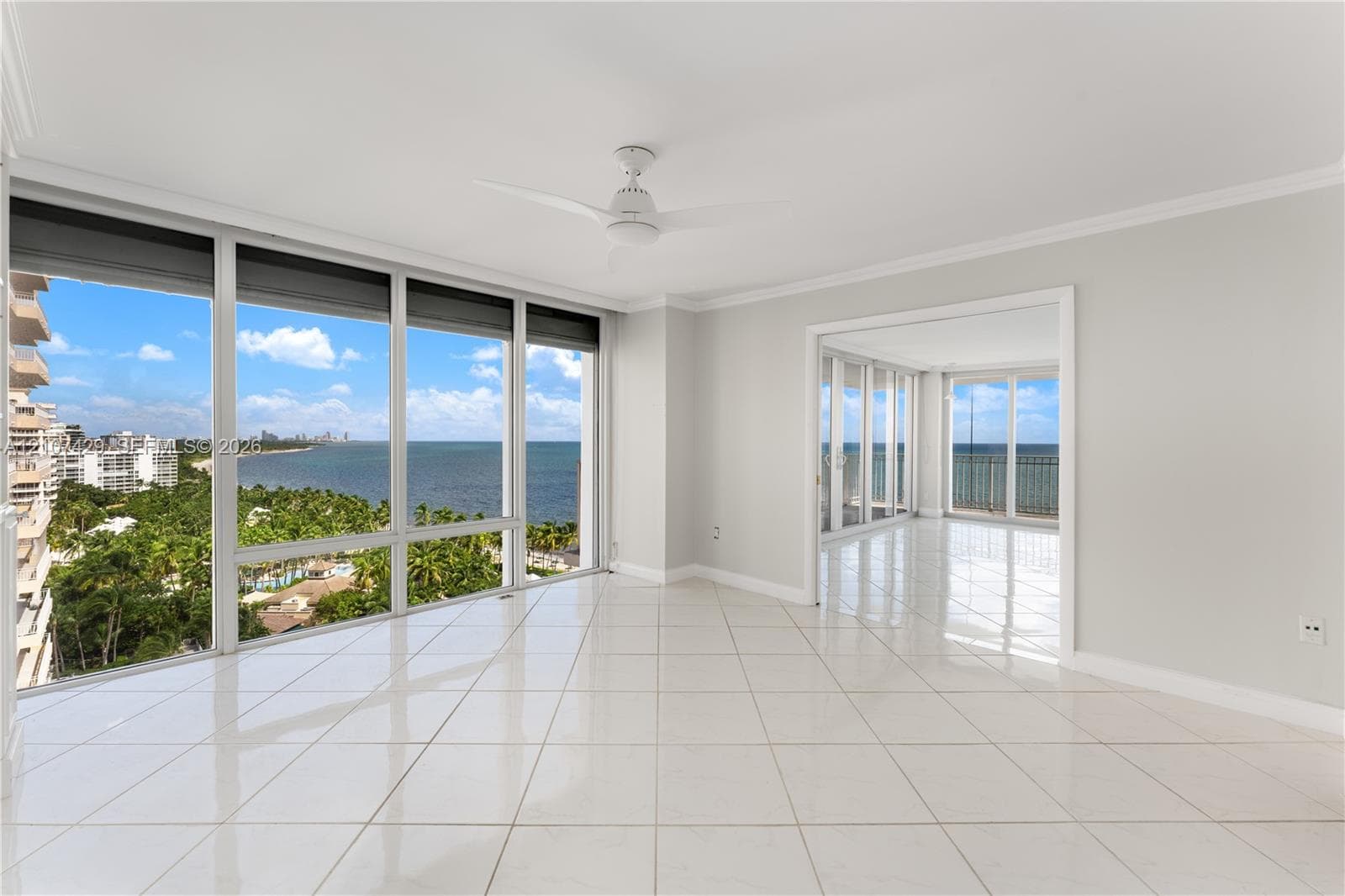 Floor-to-ceiling windows featuring panoramic coastal and ocean scenery, neutral wall tones, and wall-to-wall carpeting