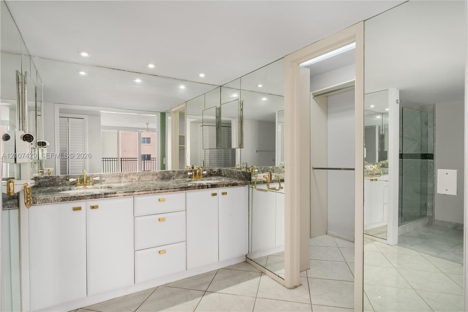 Walk-in shower featuring large-format stone tile, a built-in bench, a glass enclosure, an integrated wall niche, and a contrasting green glass tile accent border