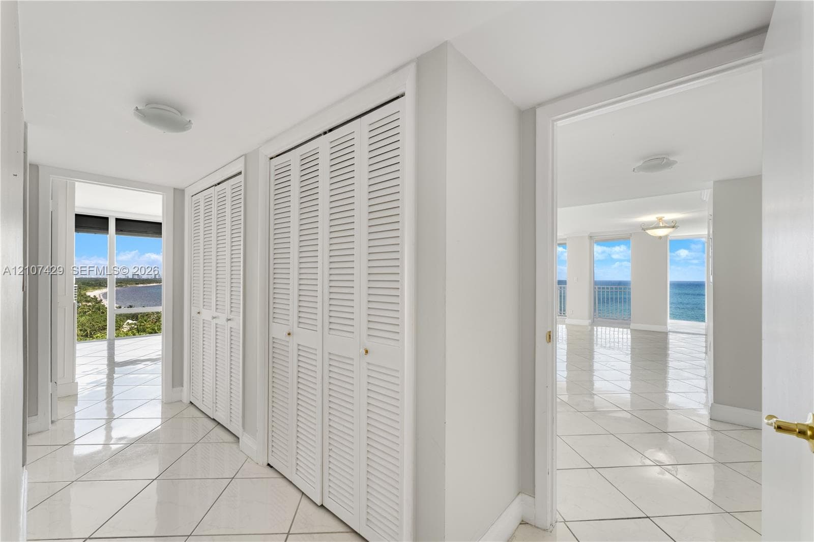 Private balcony featuring tile flooring and a metal railing, providing an elevated outlook of the coastline and surrounding landscape