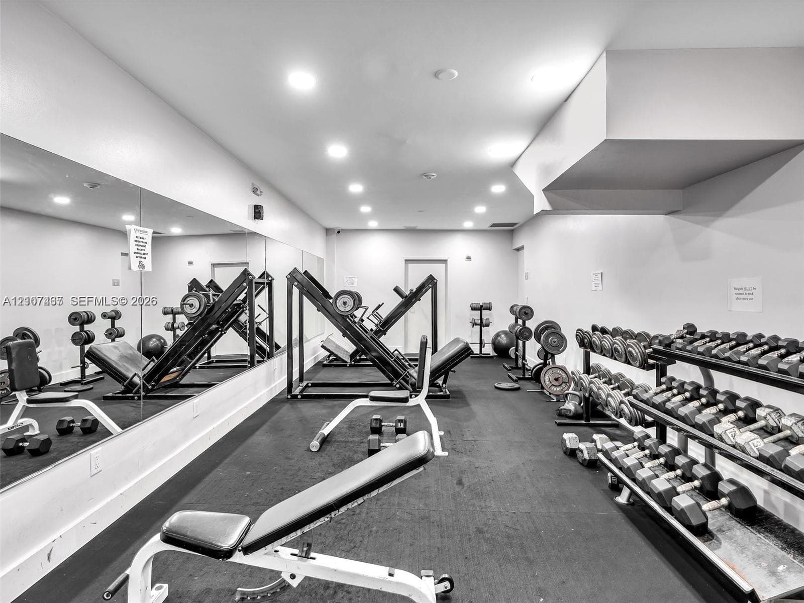 Fitness room featuring full-wall mirrors and rubberized athletic flooring