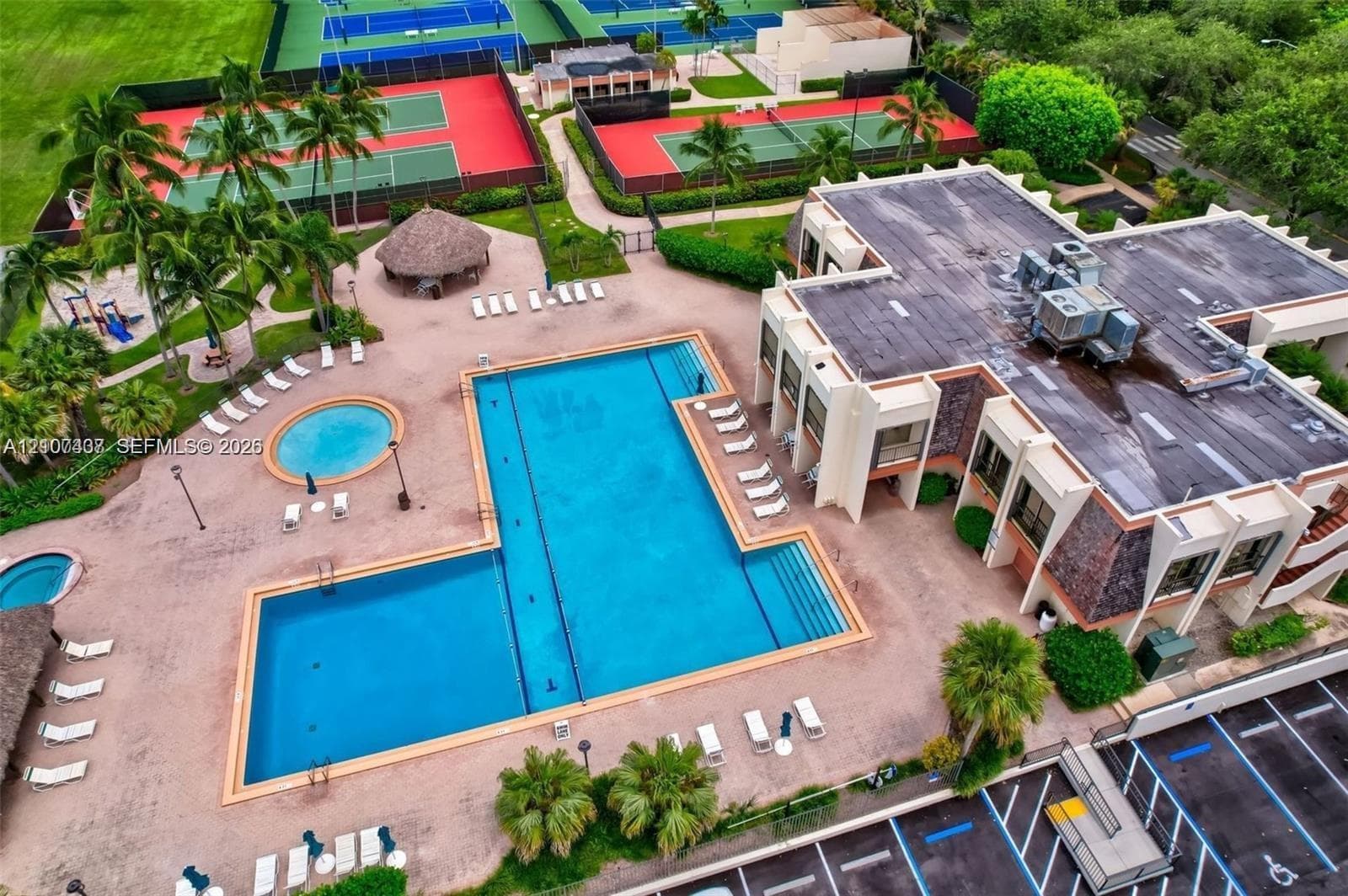 Recreational grounds featuring a swimming pool, spa, multiple tennis courts, and a thatched-roof pavilion