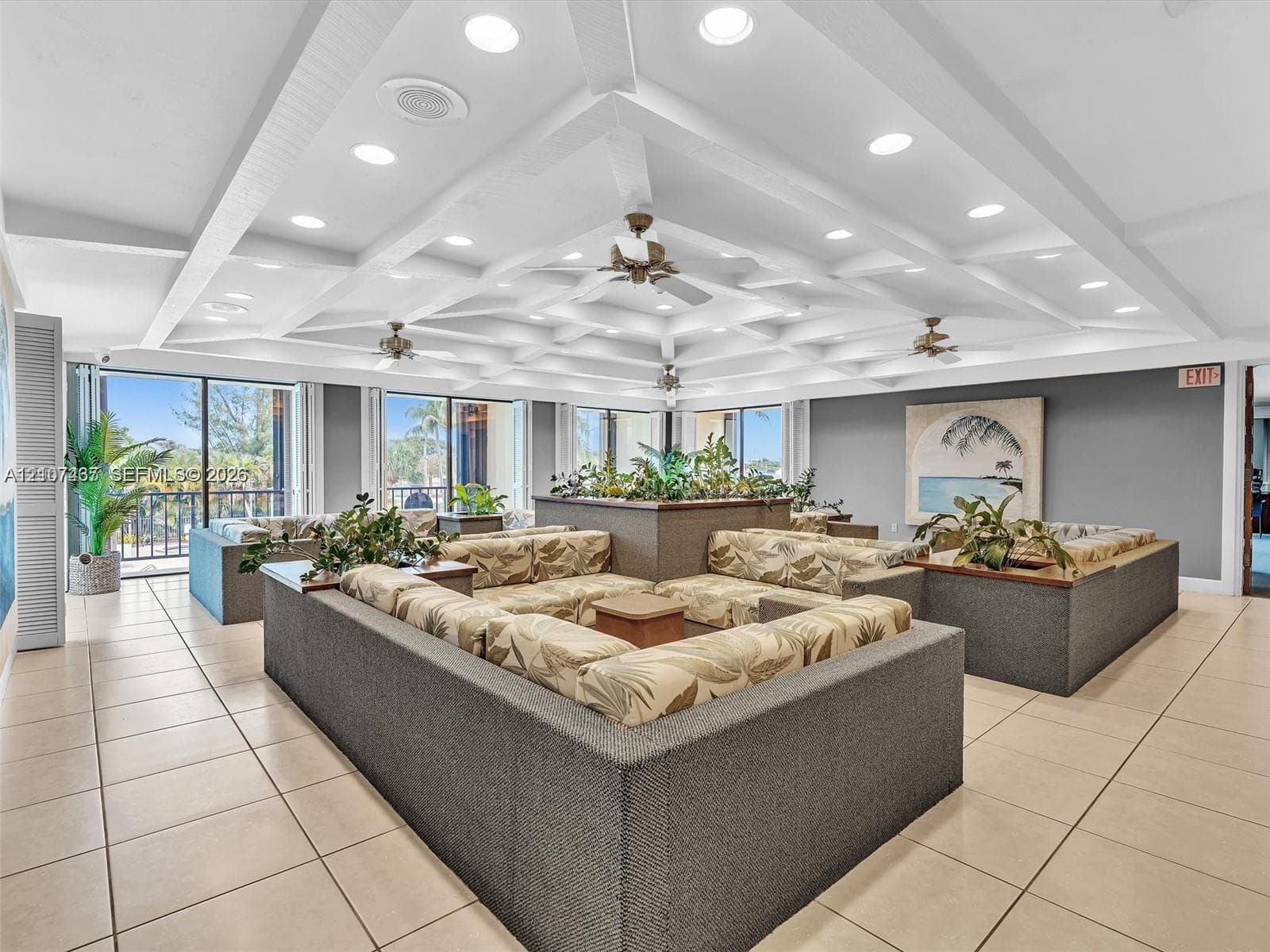 Coffered ceiling featuring recessed lighting, large-format tile flooring, and multiple floor-to-ceiling glass doors