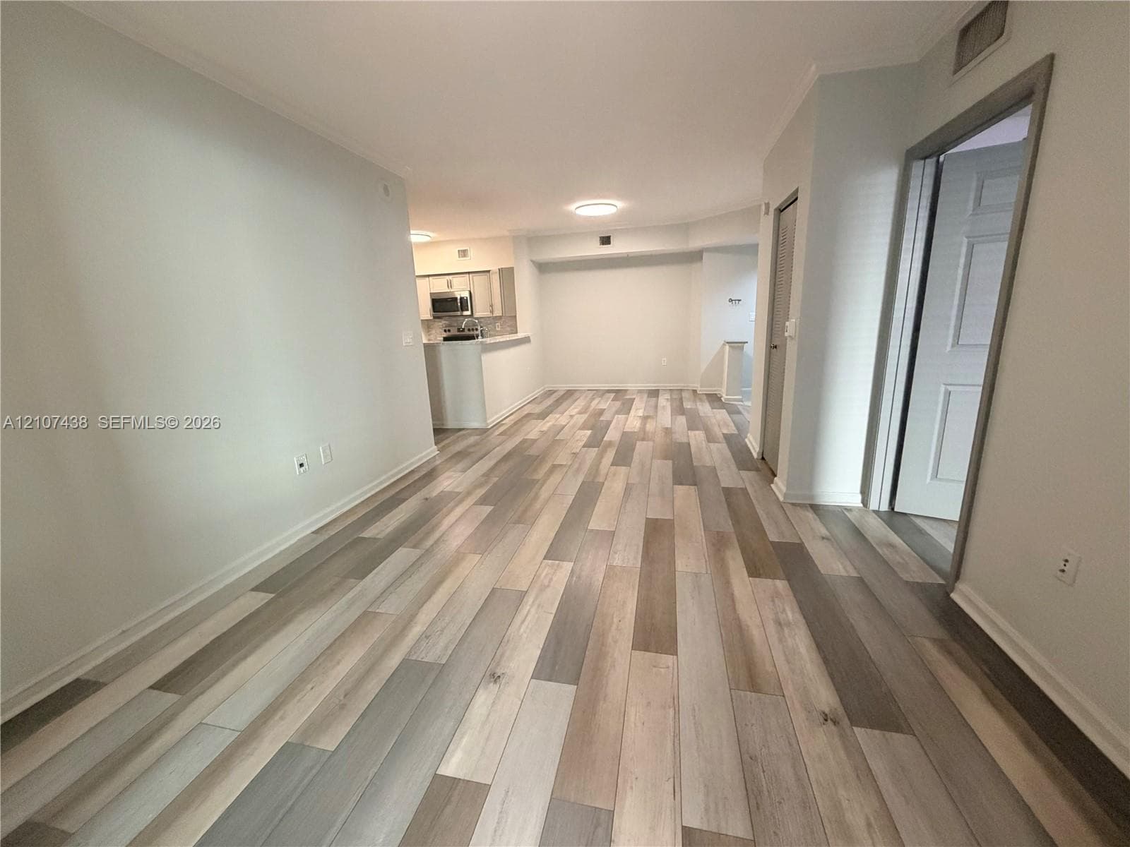 Interior space featuring wood-finish flooring, recessed ceiling lighting, and a kitchen peninsula with integrated cabinetry