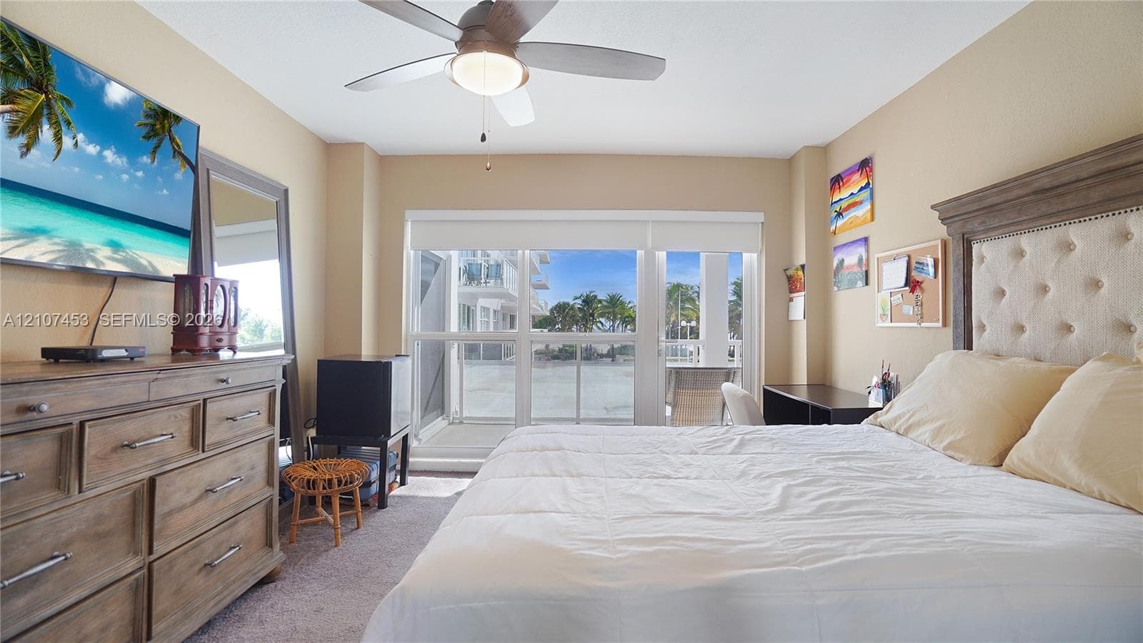 Room featuring carpeted flooring, a ceiling fan with integrated lighting, and a glass-paneled door opening to an exterior balcony