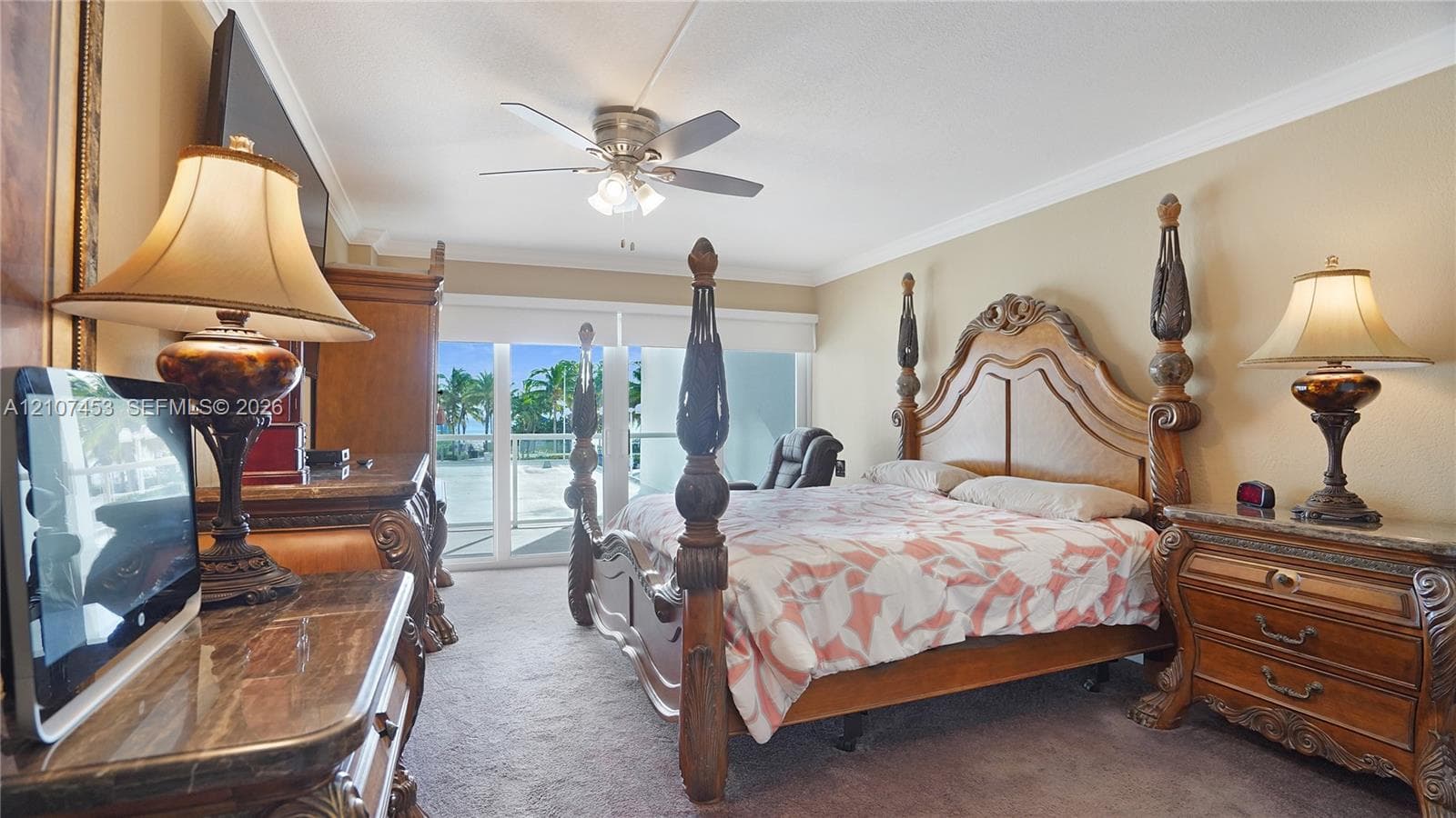 Carpeted interior featuring a ceiling fan with integrated lighting and sliding glass doors with access to an exterior balcony
