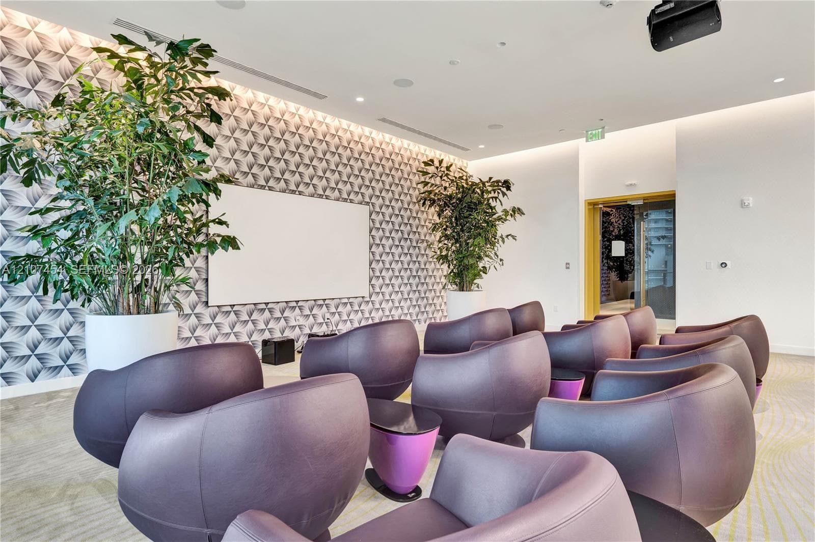 Patterned accent wall with integrated projection screen, recessed ceiling lighting, and overhead projector installation