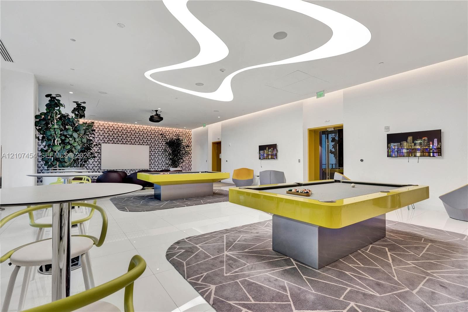 Expansive recreation space featuring custom curvilinear LED ceiling lighting, large-format polished tile flooring, and a decorative patterned accent wall