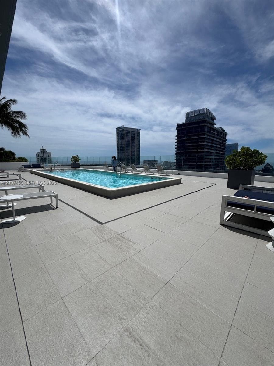 High-rise balcony featuring a glass panel railing and expansive urban skyline outlook
