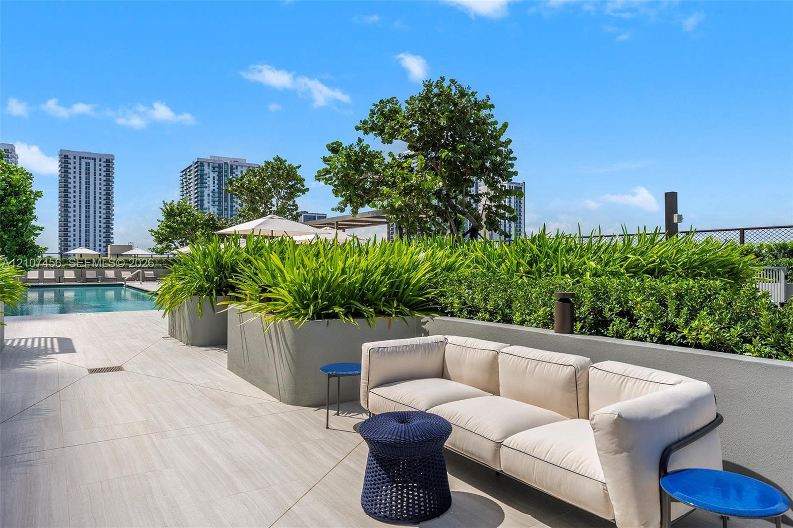 Rooftop terrace featuring large-format tile flooring, integrated concrete planters, and a swimming pool