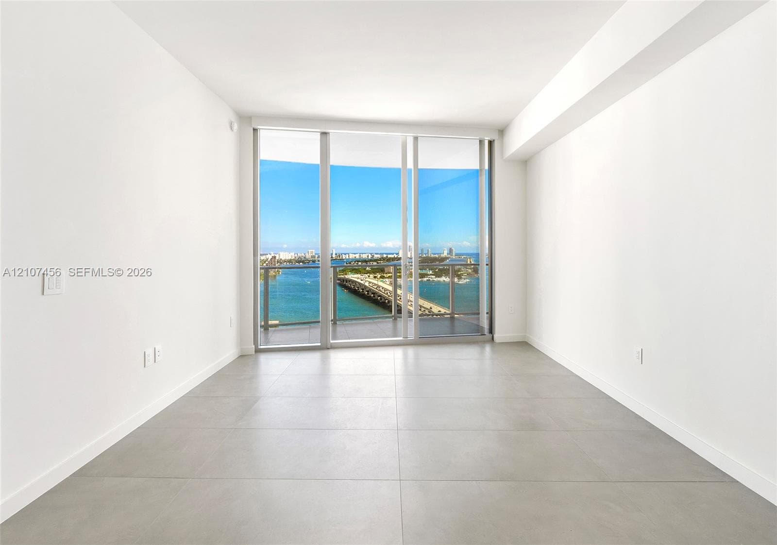 Floor-to-ceiling glass windows, private balcony, and large-format tile flooring