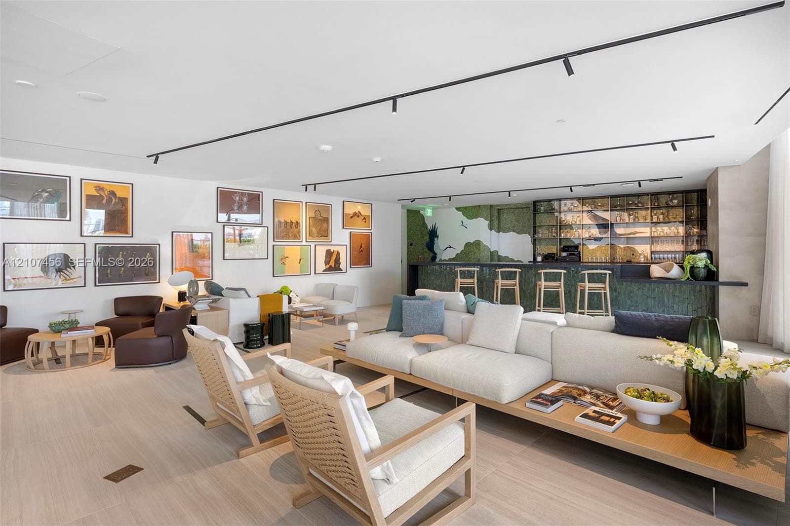 Open-concept living space featuring wood-finish flooring, recessed track lighting, and a built-in bar with glass-front cabinetry