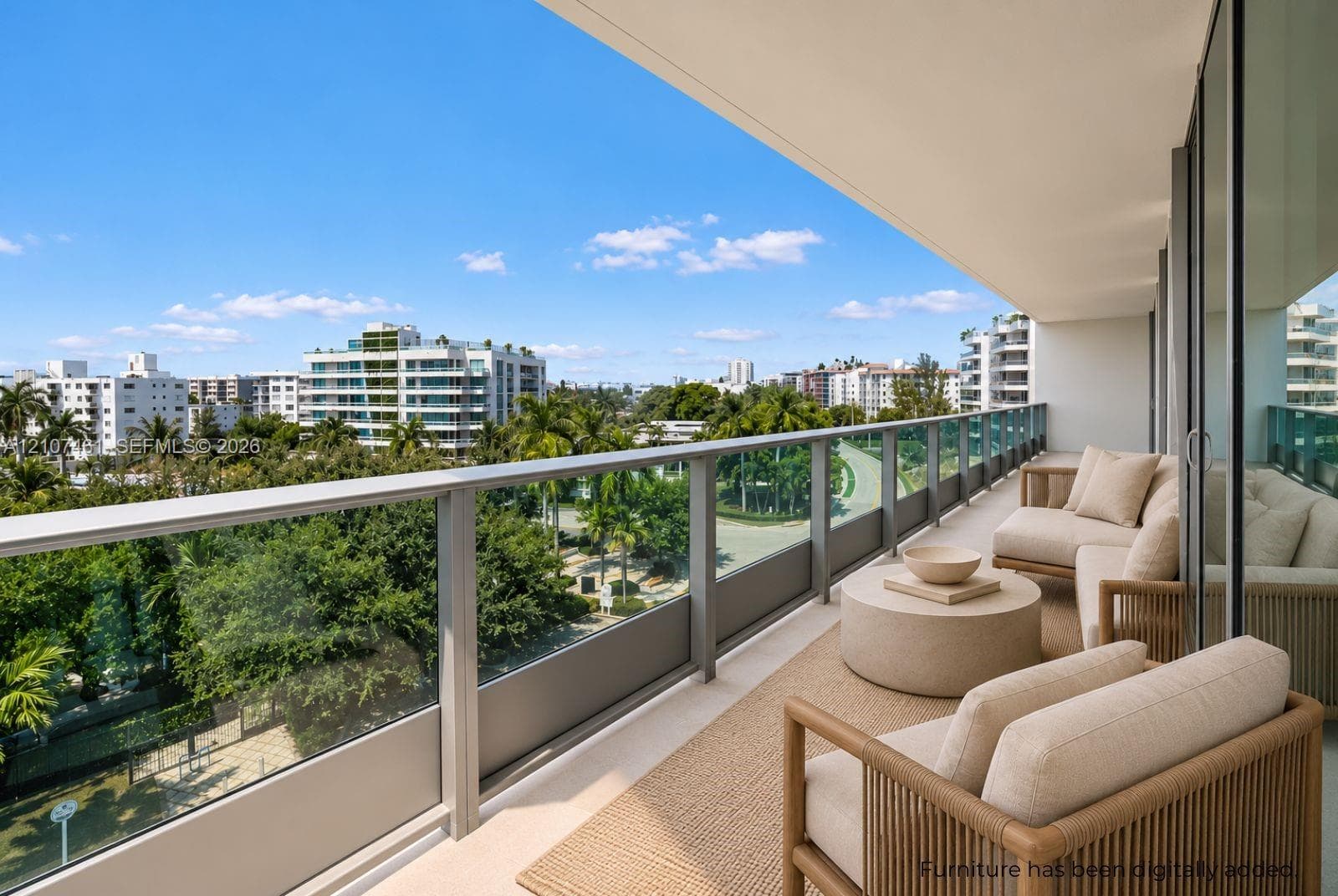 Expansive covered balcony featuring a glass and metal railing, concrete flooring, and full-height sliding glass doors