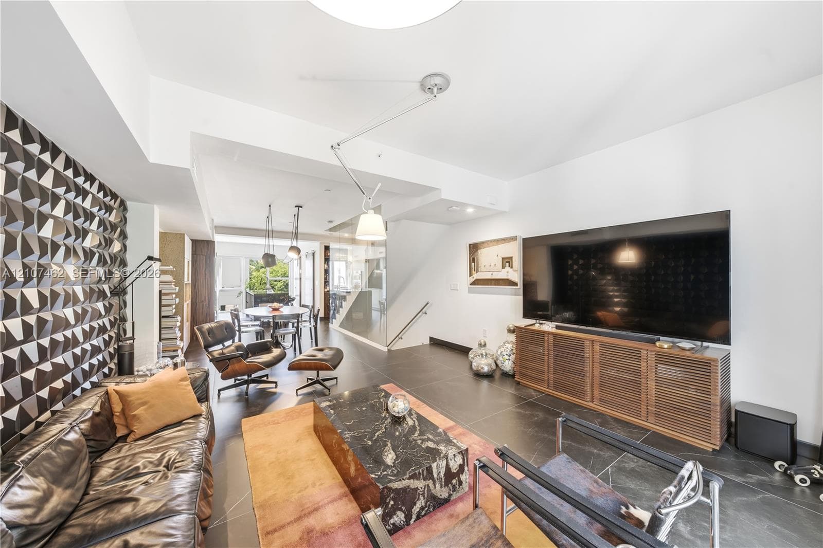 Textured dimensional wall paneling, large-format tile flooring, and integrated adjustable pendant lighting