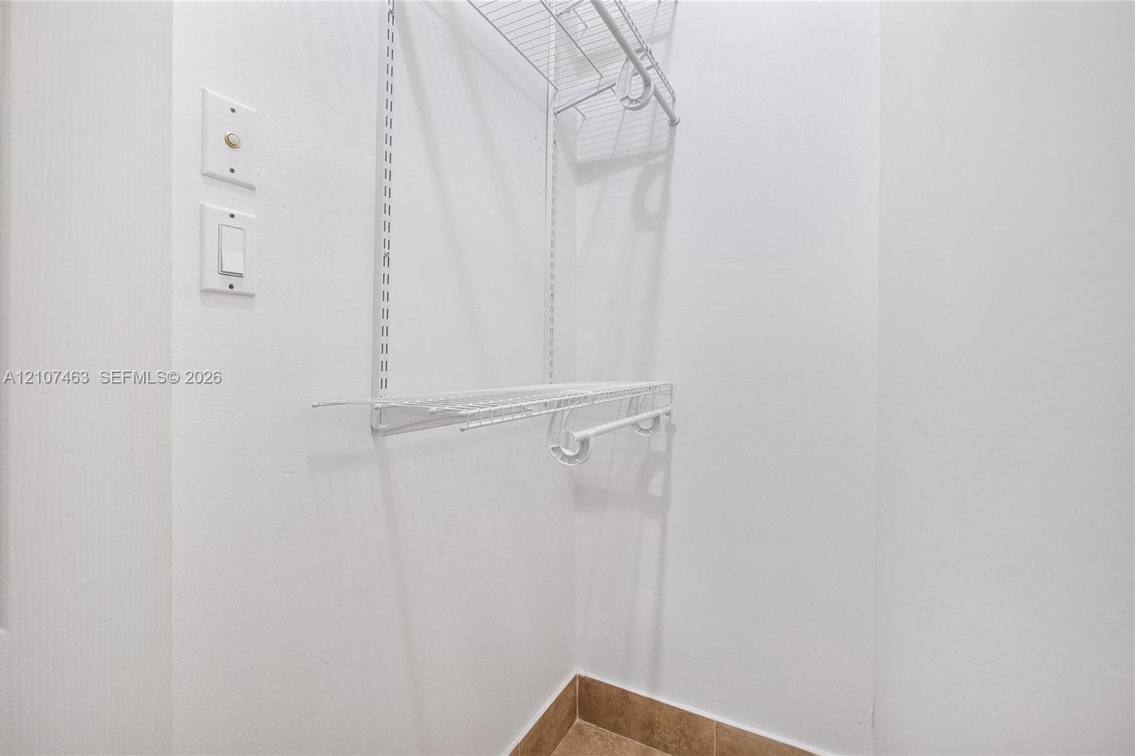 Room 3 Closet Storage area featuring white wire shelving, a built-in hanging rod, and ceramic tile flooring