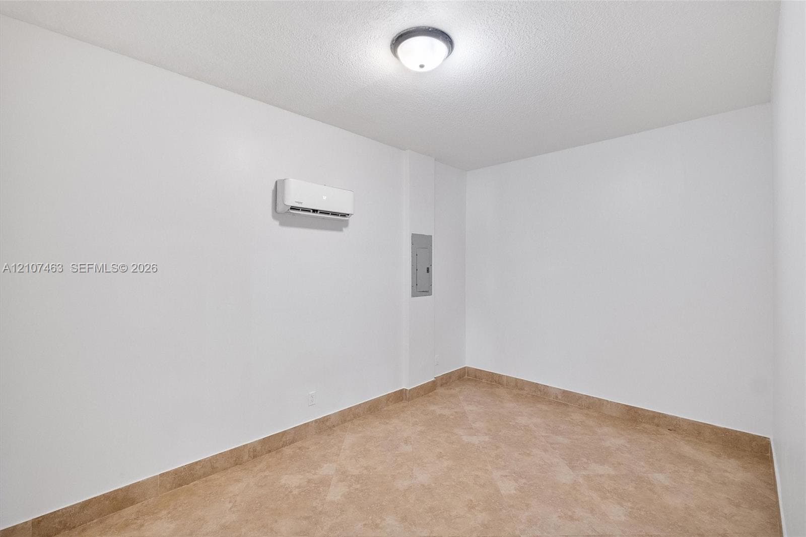 Room 3 featuring tile flooring, a wall-mounted ductless air conditioning unit, and a flush-mount ceiling light fixture