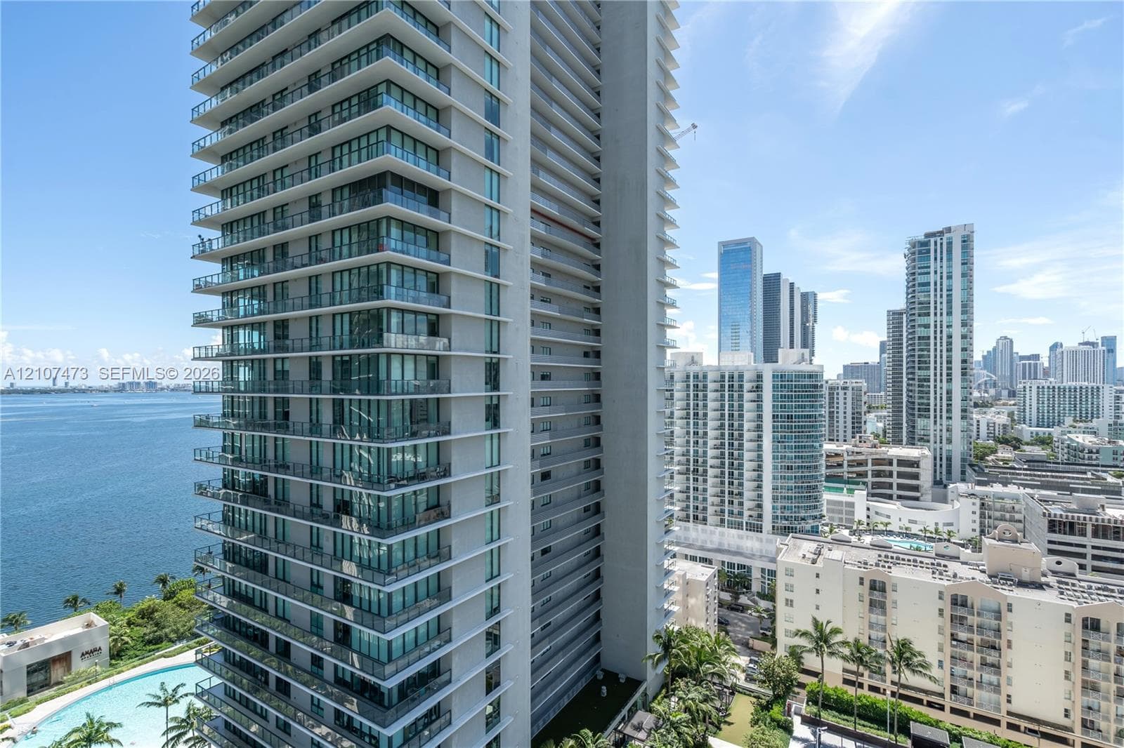 High-rise tower featuring floor-to-ceiling glass windows, expansive private wraparound balconies, and a reinforced concrete facade