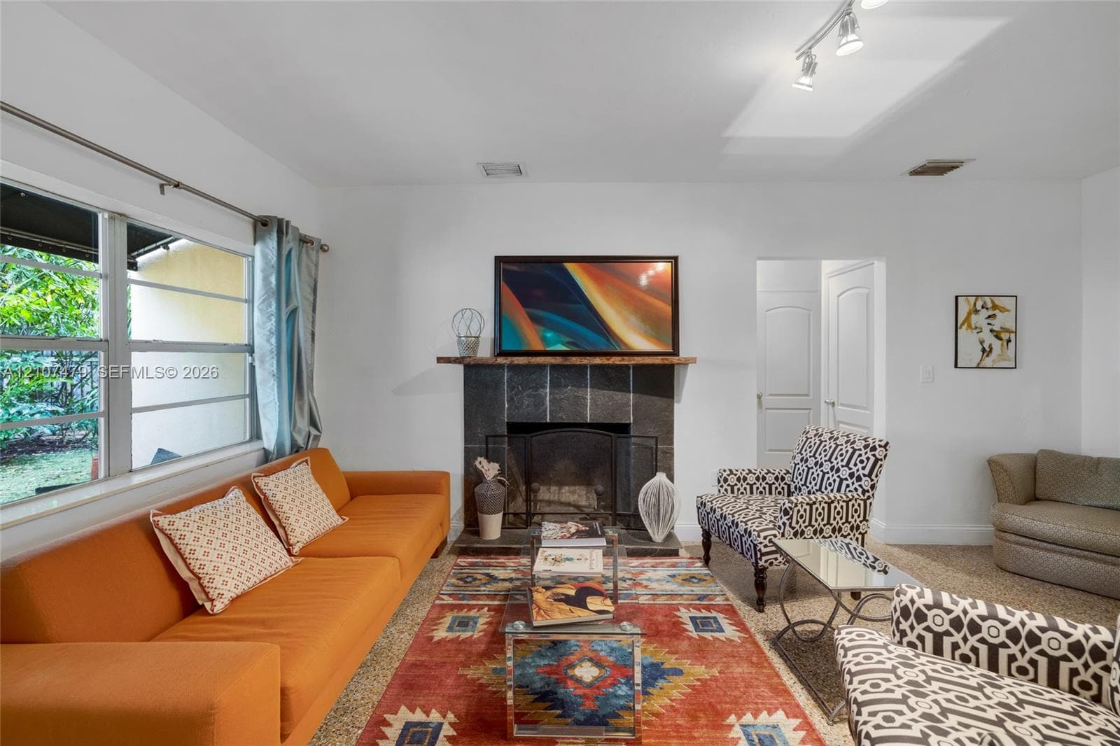 Ceramic tile flooring, multi-directional ceiling track lighting, ceiling fan with integrated light fixture, and large rectangular windows