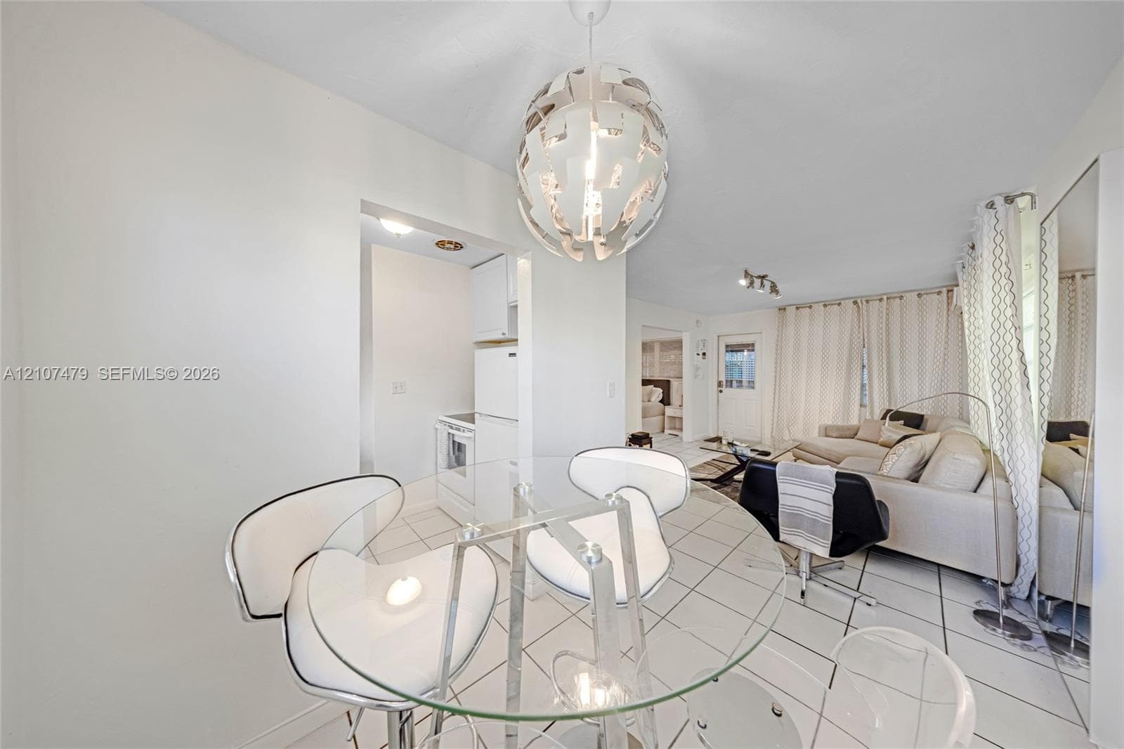 Interior space featuring white ceramic tile flooring, a multi-blade ceiling fan with integrated lighting, and horizontal window blinds