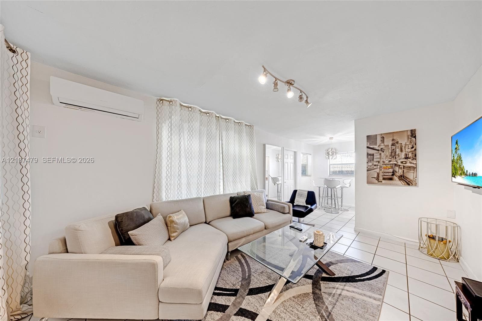 Bright living area featuring ceramic tile flooring, neutral wall tones, and track lighting