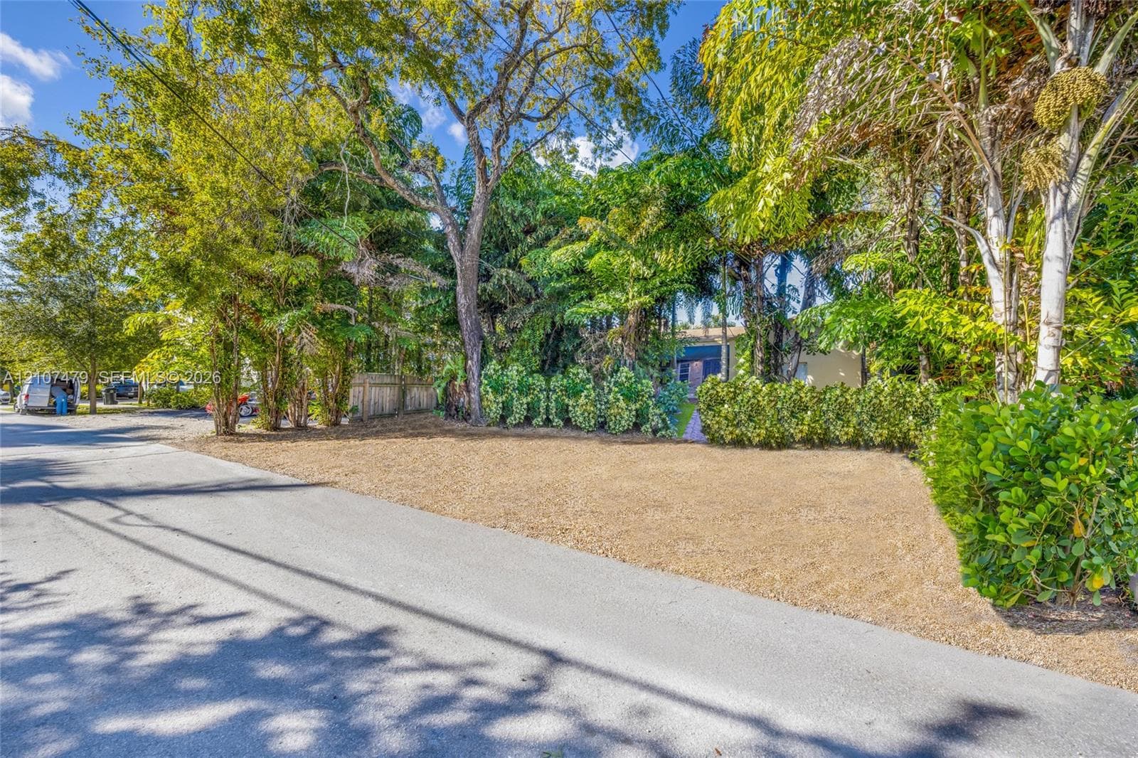 Side yard area featuring gravel ground cover, natural stone paver pathway, and mature tree landscaping