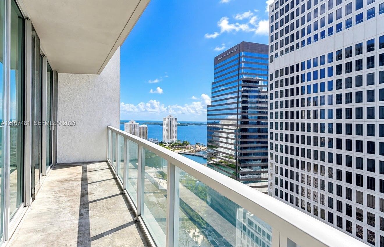 Covered balcony with glass panel railing and concrete flooring