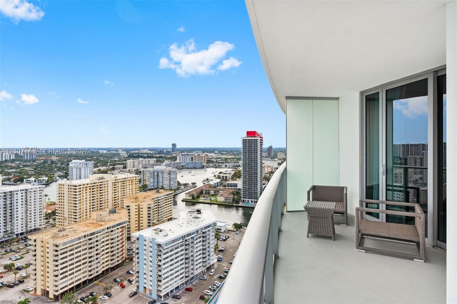 Covered balcony featuring glass panel railings and multi-panel sliding glass doors