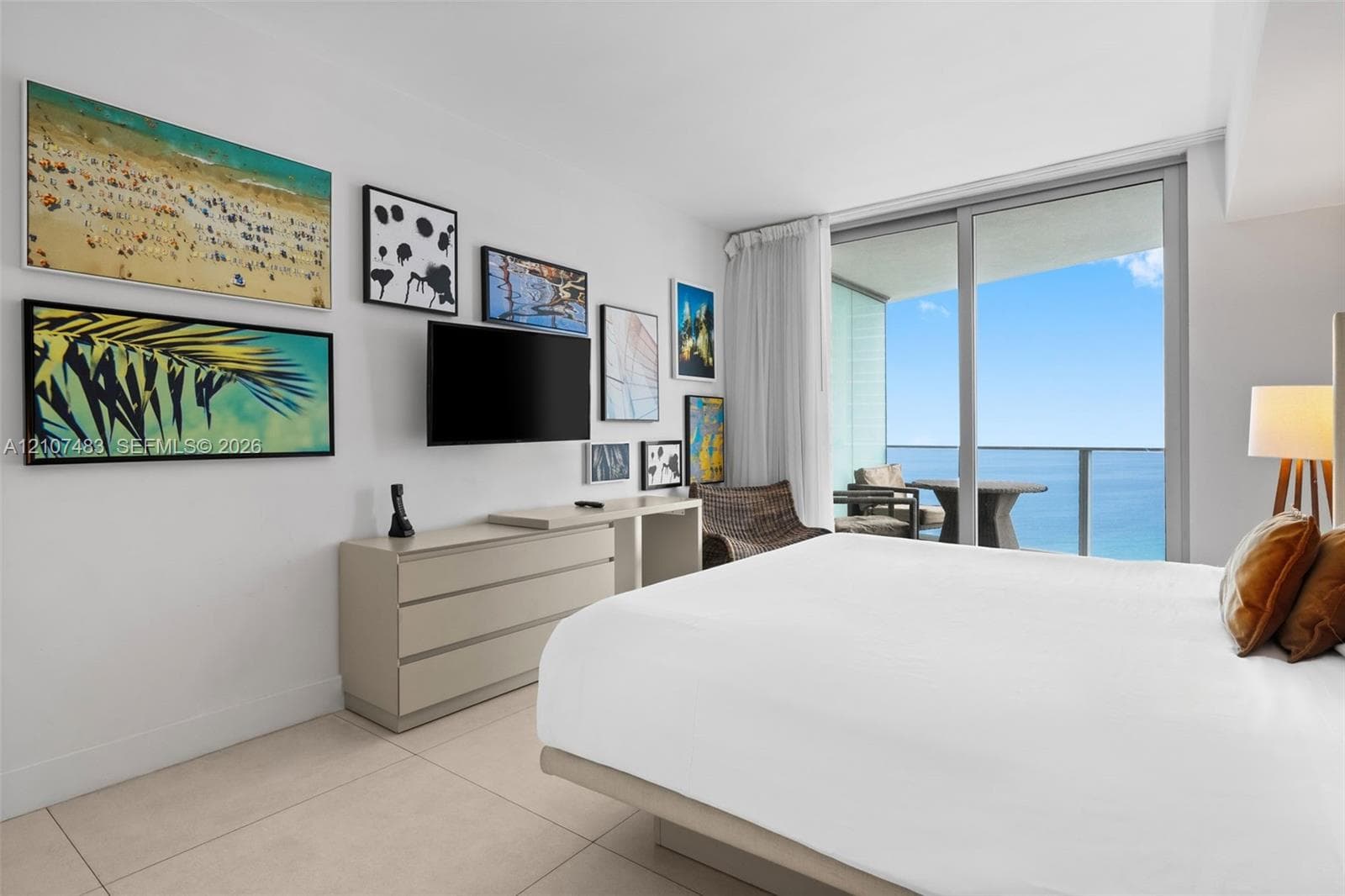 Floor-to-ceiling sliding glass doors, private balcony, large format tile flooring, and neutral wall palette