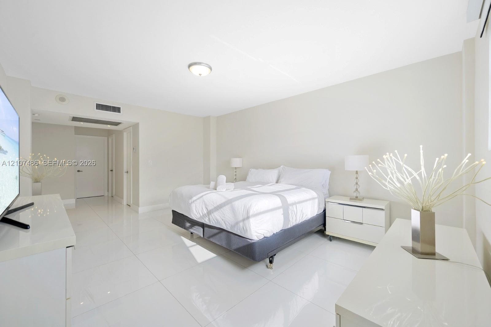 Spacious room featuring high-gloss large-format tile flooring, neutral wall finishes, recessed lighting, and integrated climate control system