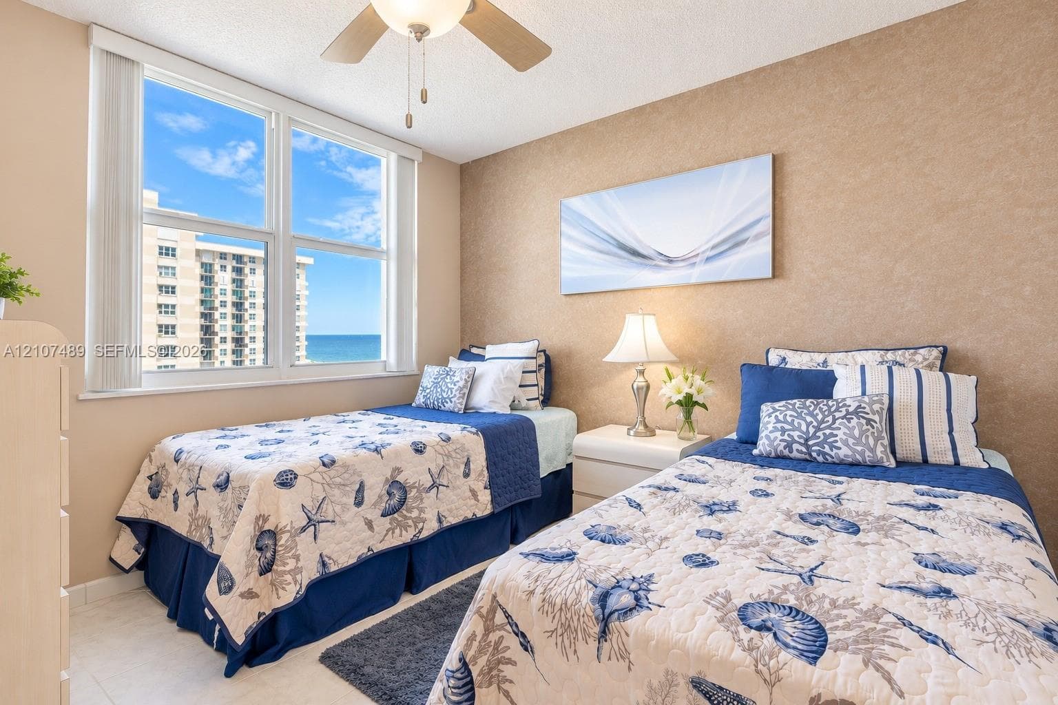 Large windows featuring natural light, neutral textured wall finish, and ceiling-mounted fan with light fixture