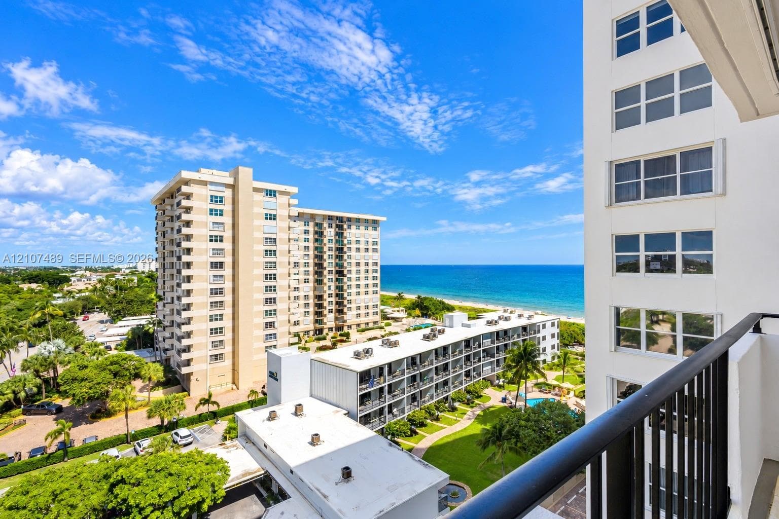 Private balcony with black metal railing, featuring ocean and coastal landscape surroundings