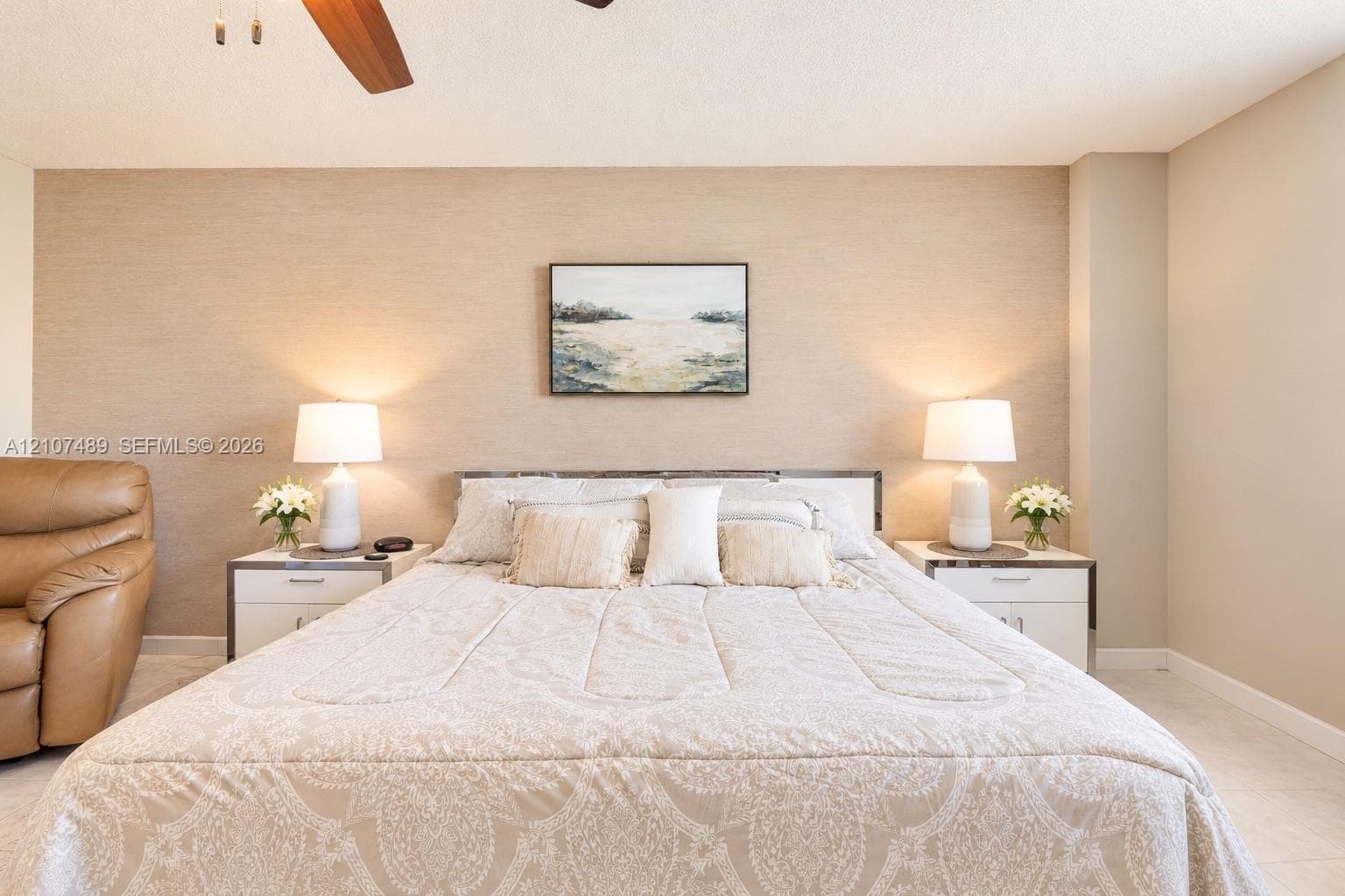 Textured accent wall featuring a neutral finish and ceiling-mounted fan