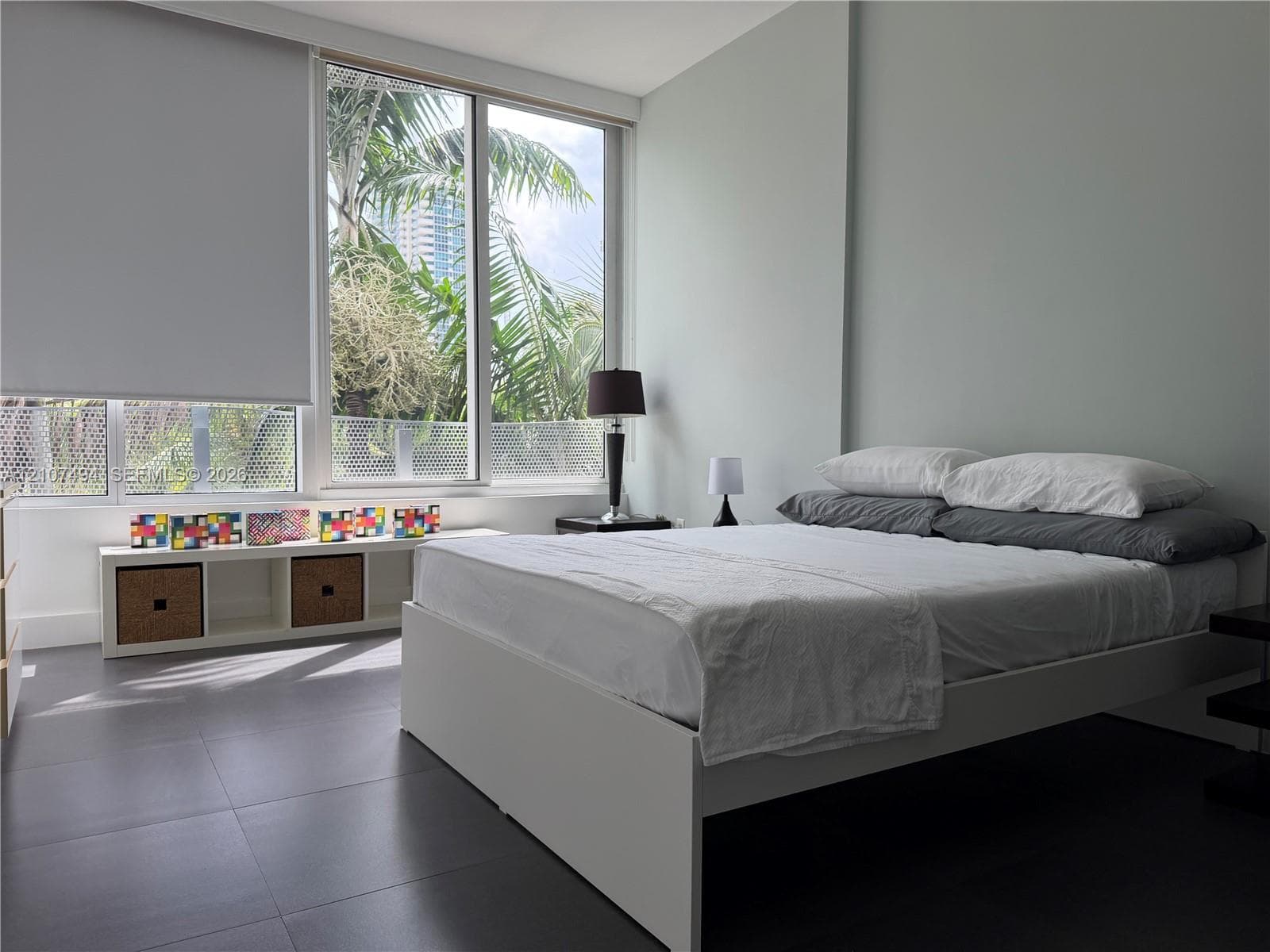 Floor-to-ceiling windows, large-format tile flooring, neutral wall finish, and retractable window shades