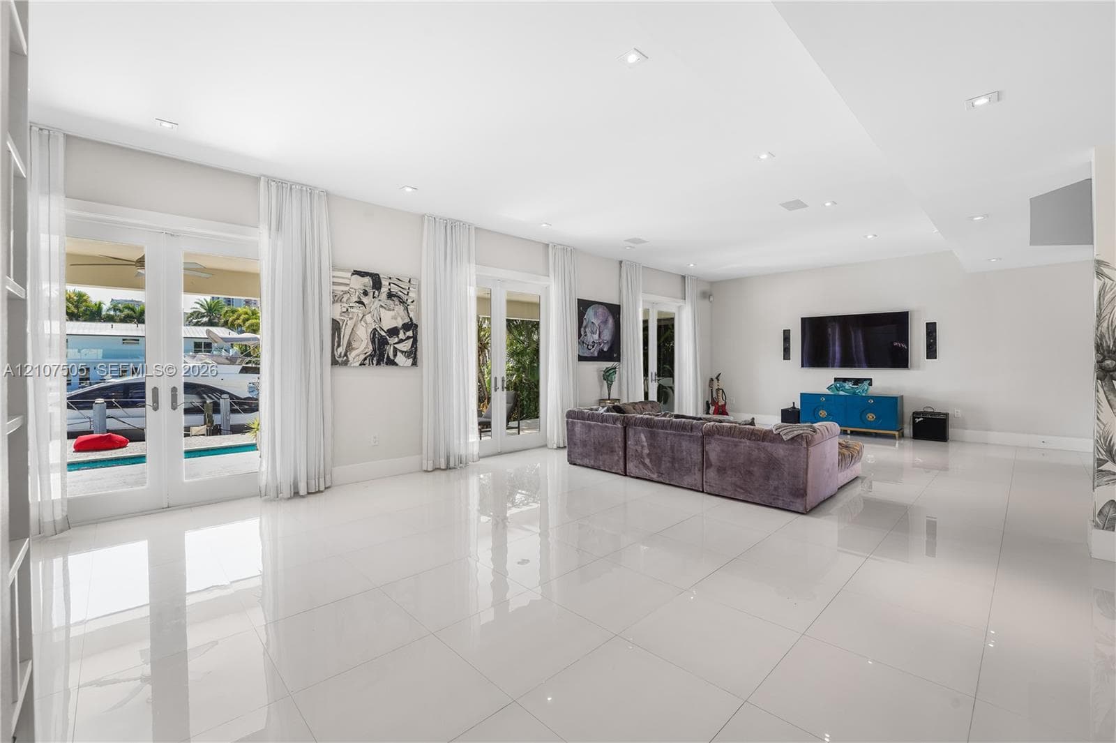 Large-format tile flooring, recessed ceiling lighting, and multiple sets of glass-paneled double doors featuring exterior access