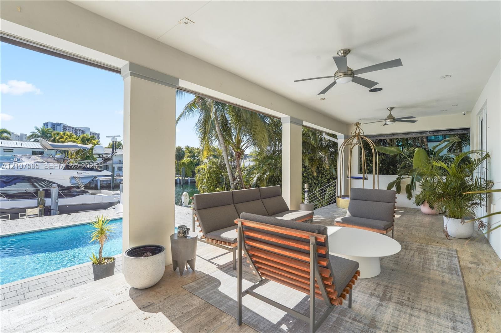 Covered patio featuring stone tile flooring, recessed lighting, ceiling fans, and structural support columns