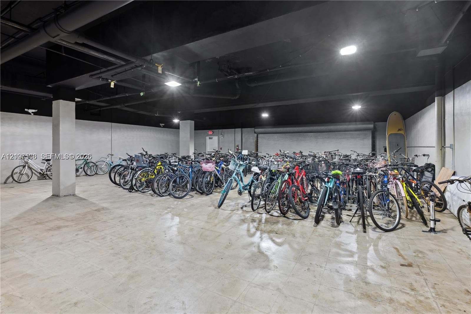 Expansive storage area featuring concrete flooring, overhead industrial-style lighting, and structural support columns