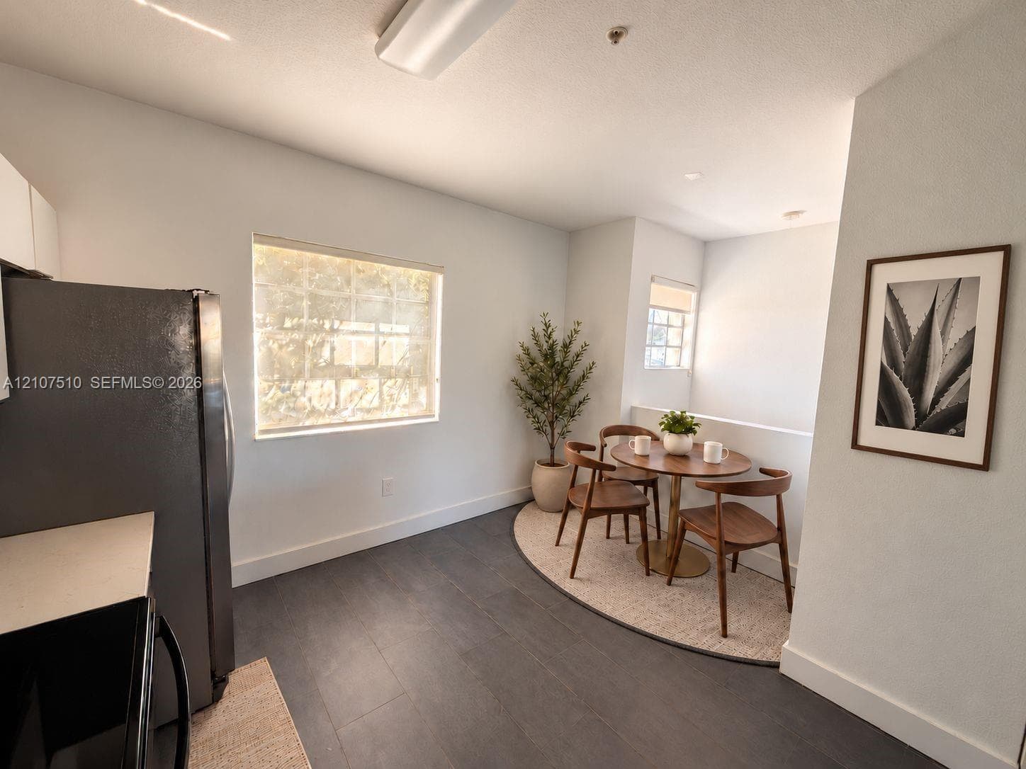 Wood-finish flooring, dual windows with roller shades, and integrated kitchen cabinetry