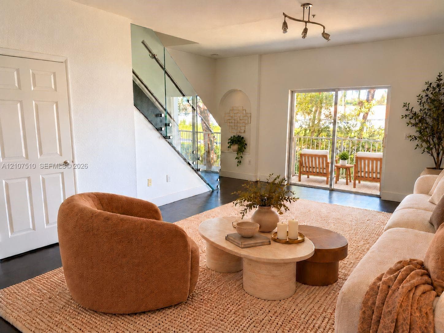 Staircase featuring a glass railing with metal hardware, dark-toned flooring, an arched built-in wall niche, and sliding glass doors with external balcony access